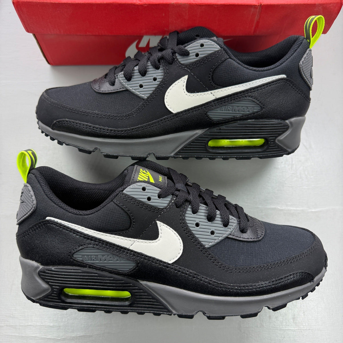 Nike trainers black with neon volt accents and white-grey detailing, featuring iconic logo.