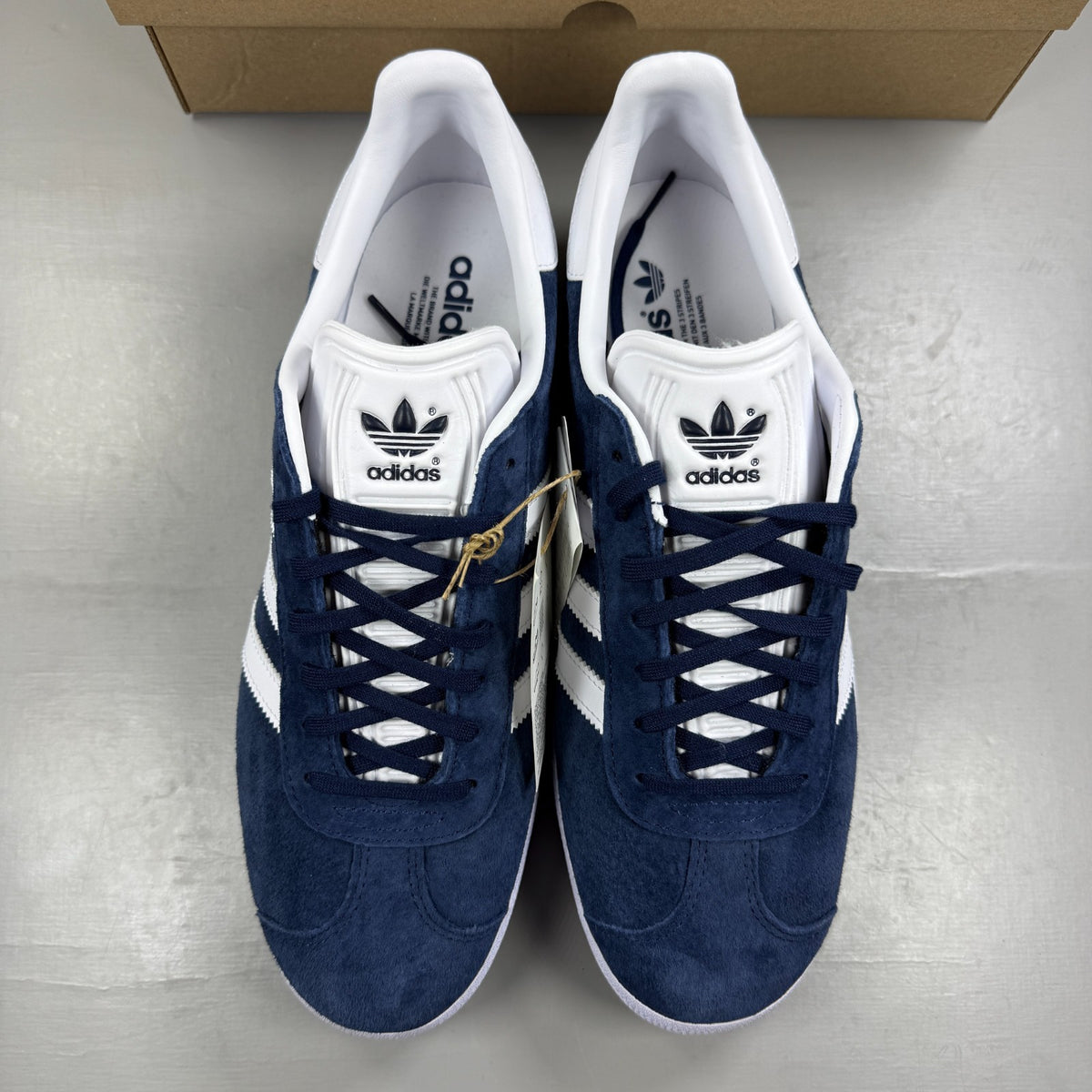 Adidas blue suede trainers with white stripes and logo detail.