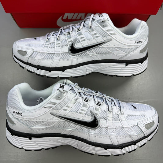 Nike white trainers with metallic silver accents and black detailing, featuring a sleek design.