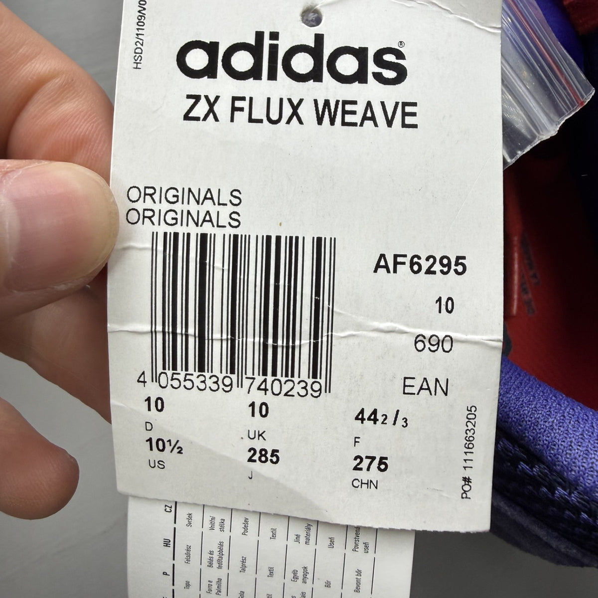Adidas blue ZX Flux trainers with red and white woven pattern, logo on tongue.