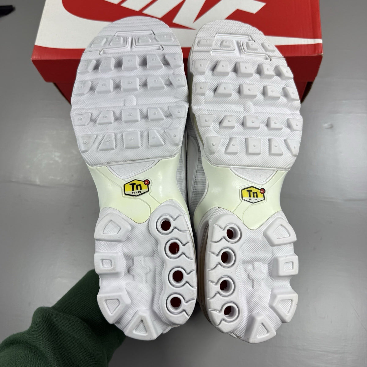 Nike Air Max Plus TN Ultra white trainers with reflective accents and signature swoosh logo.