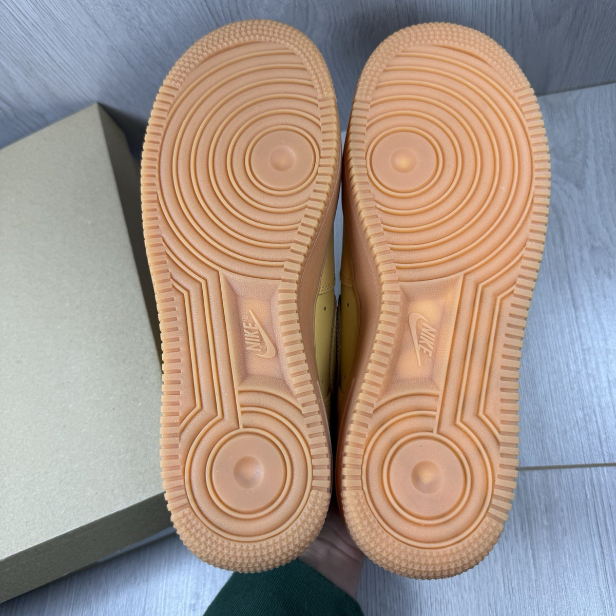 Nike Air Force 1 trainers brown suede upper with gum sole and logo detail.