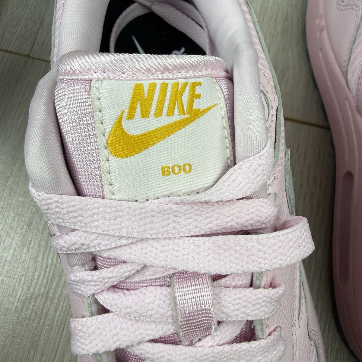 Nike Air Max 1 trainers pink with silver accents and unique design details.