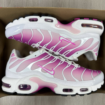 Nike Air Max Plus TN white trainers with fire pink foam fade and logo detailing.