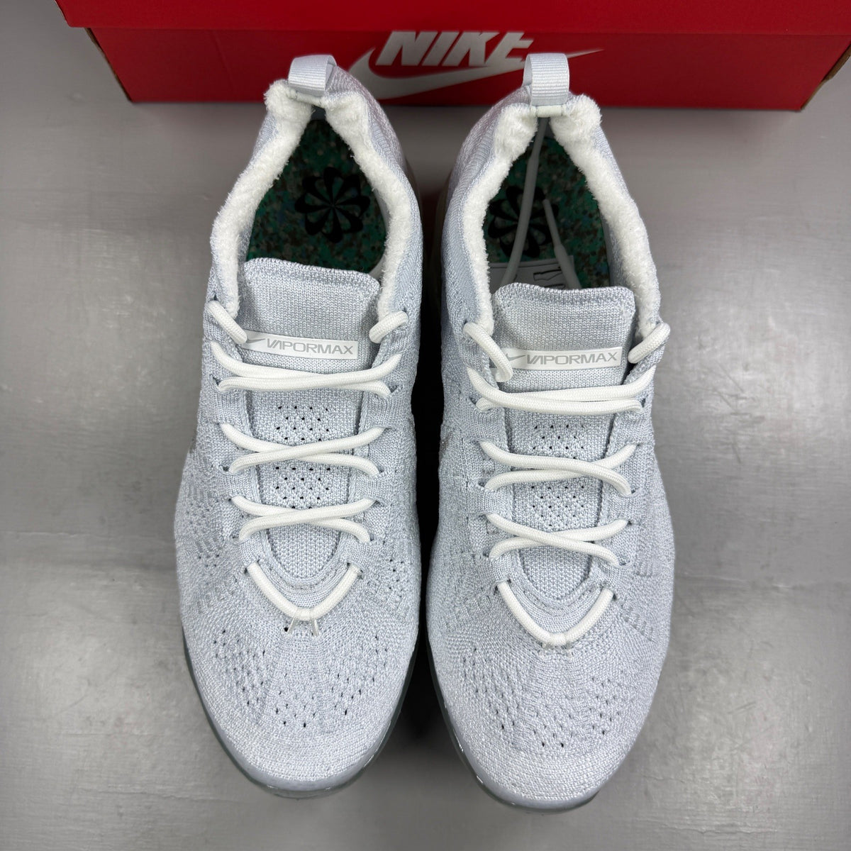 Nike trainers white Flyknit upper with Air cushioning and logo detail.