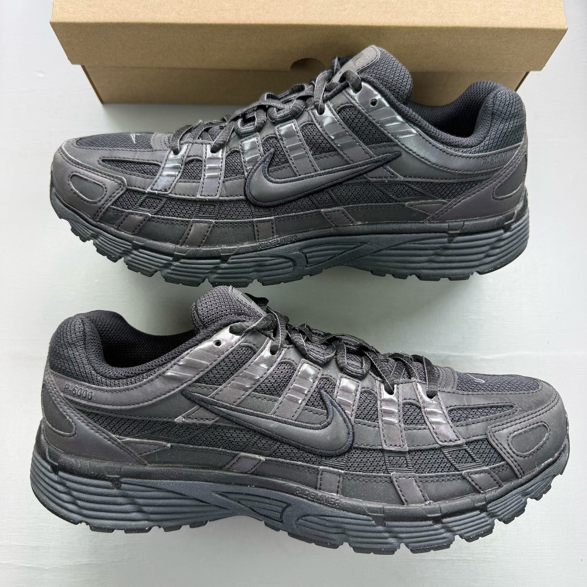 Nike black trainers with reflective detailing and logo on the side.