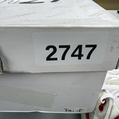 Nike Air Max 1 white trainers with red accents and classic logo detailing.