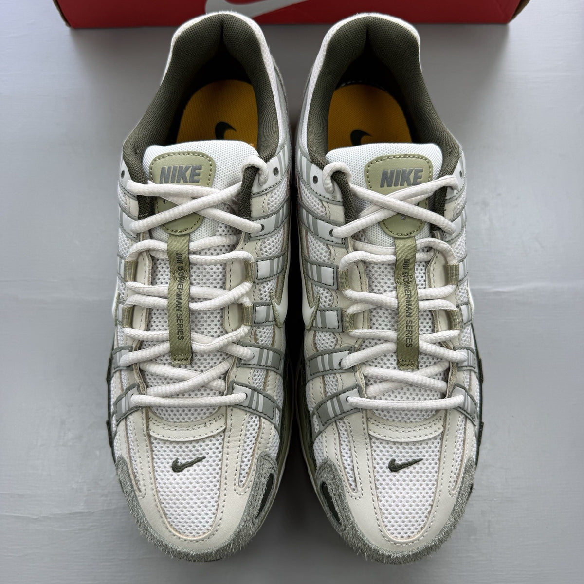 Nike white trainers with light army accents and breathable mesh upper.
