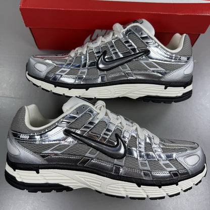 Nike P-6000 metallic silver trainers with black accents and white detailing.