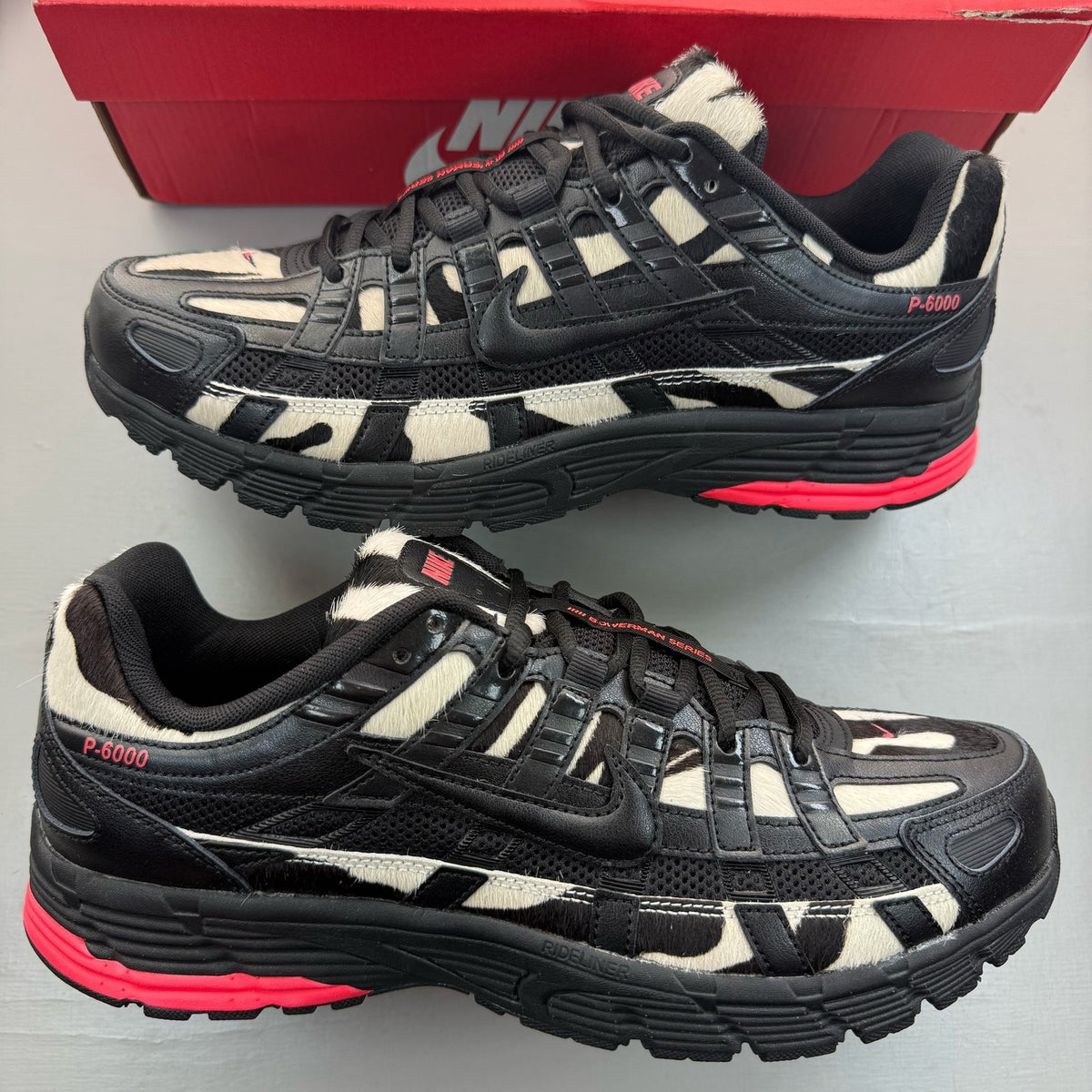 Nike black trainers with zebra pattern, solar red accents, and white detailing.