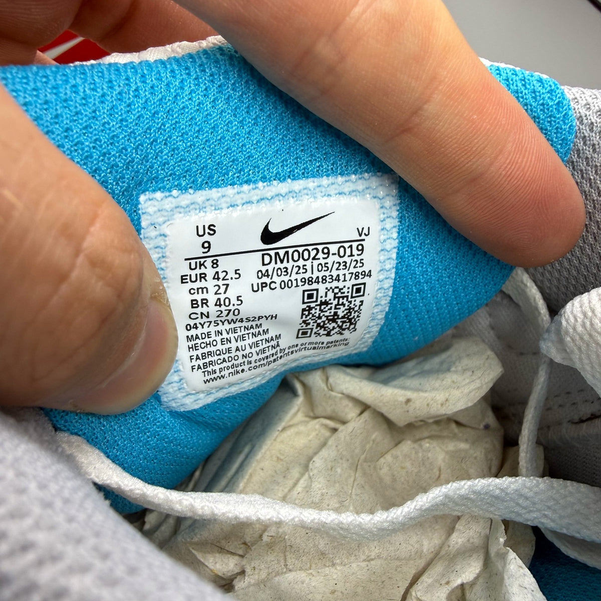 Nike Air Max 90 grey trainers with blue accents and signature swoosh logo.