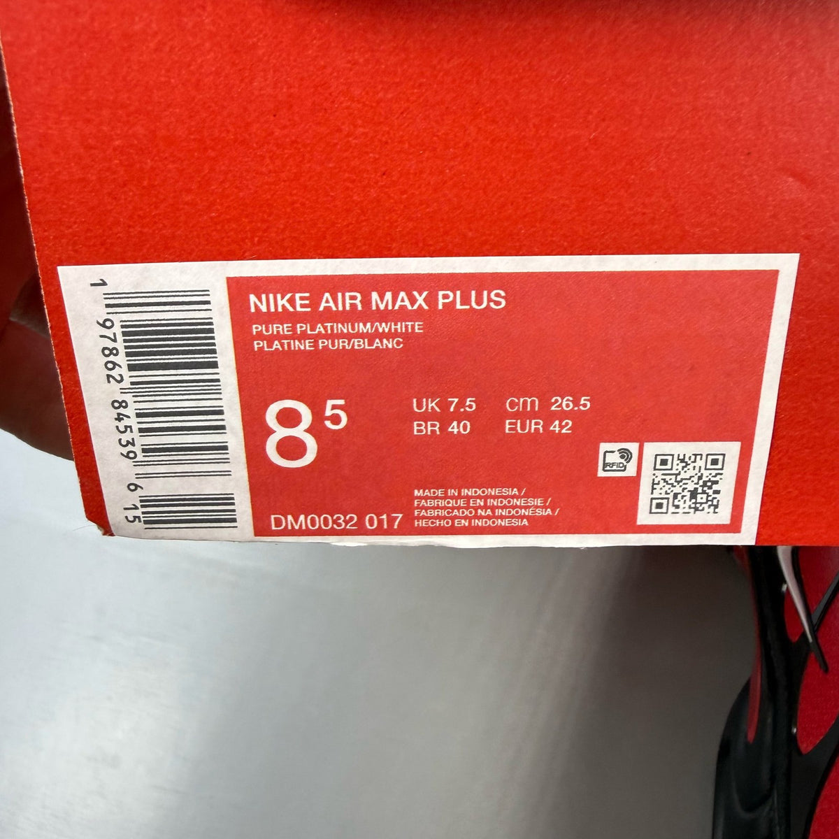 Nike Air Max Plus TN red with pure platinum accents and iconic logo detail.
