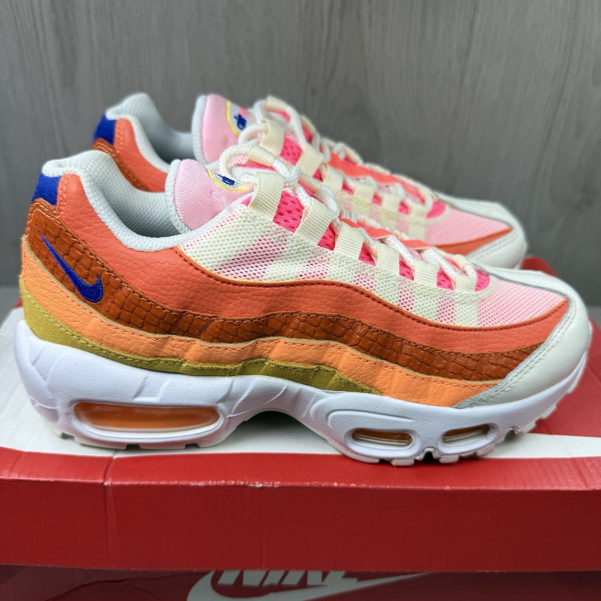 Nike Air Max 95 trainers white with campfire orange accents and signature logo details.