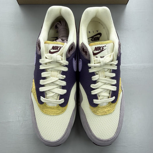 Nike Air Max 1 87 trainers grey with violet accents and signature swoosh logo.