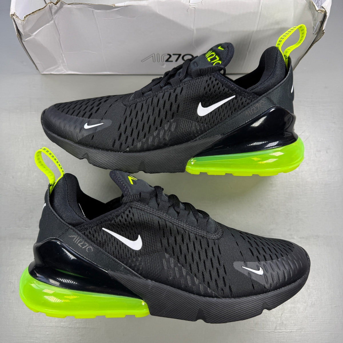 Nike running shoes black with volt neon accents and Air Max cushioning.