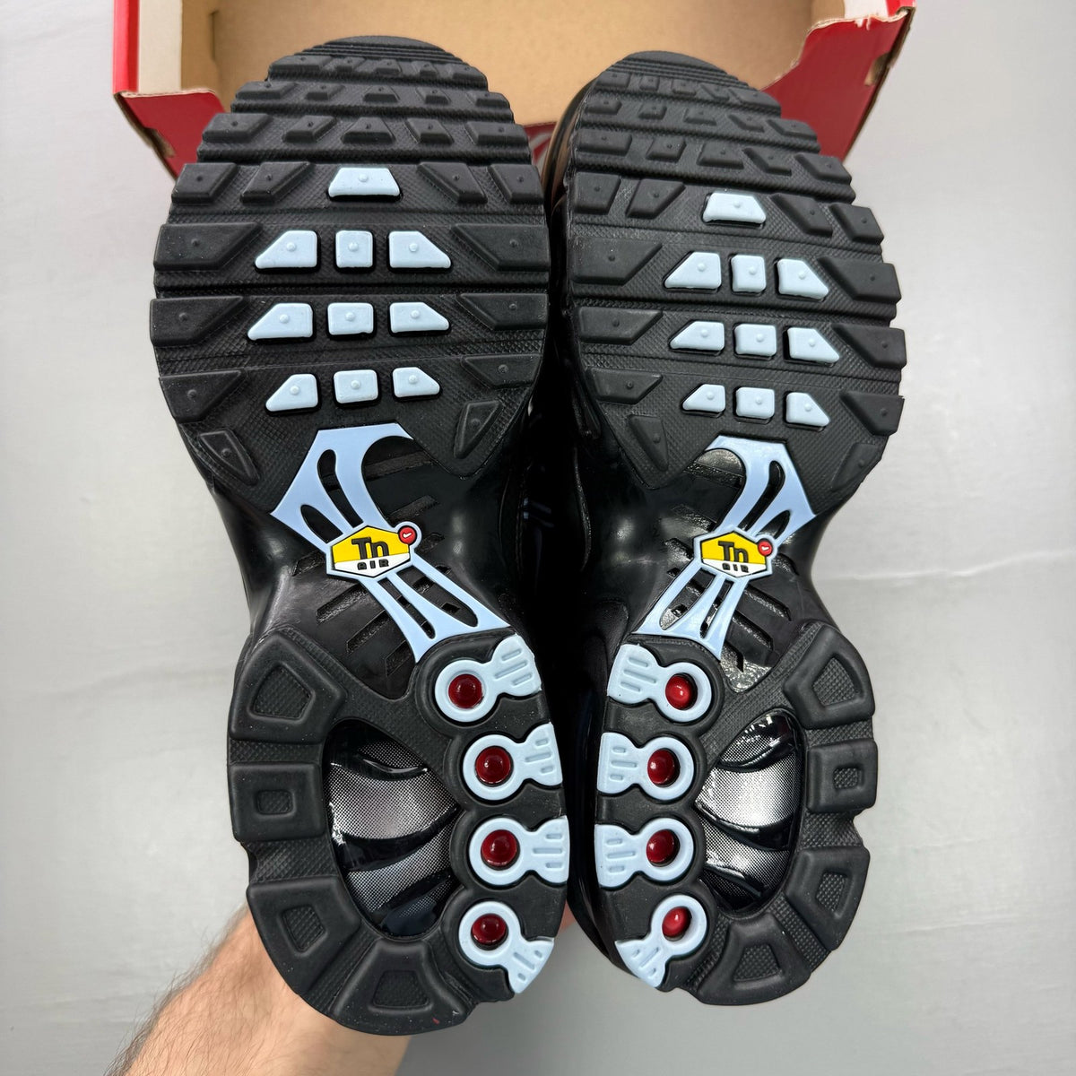 Nike Air Max Plus TN Tuned black trainers with grey accents and signature logo.
