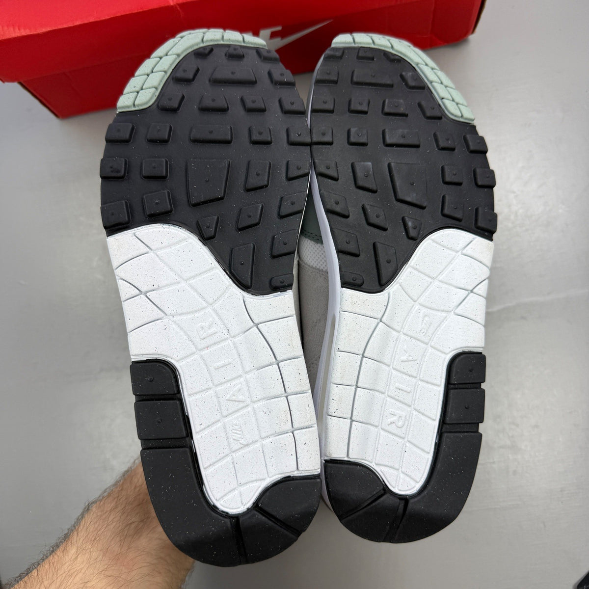 Nike trainers white with grey accents and green detailing, featuring iconic swoosh logo.