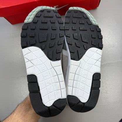 Nike trainers white with grey accents and green detailing, featuring iconic swoosh logo.