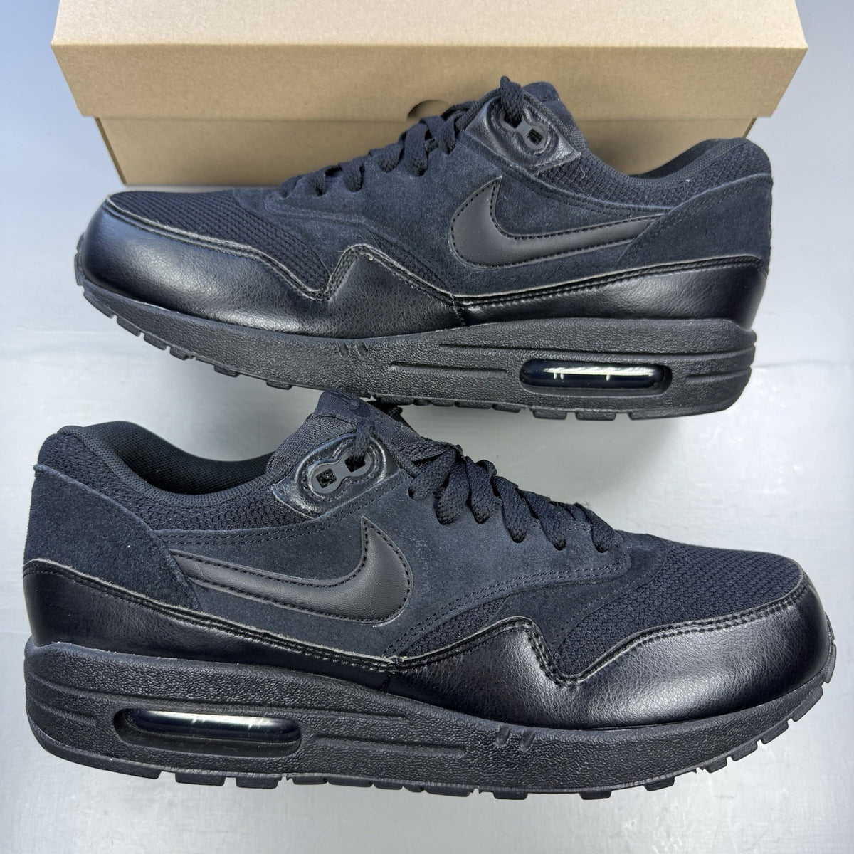 Nike black Air Max 1 Essential trainers with signature swoosh logo and mesh detailing.