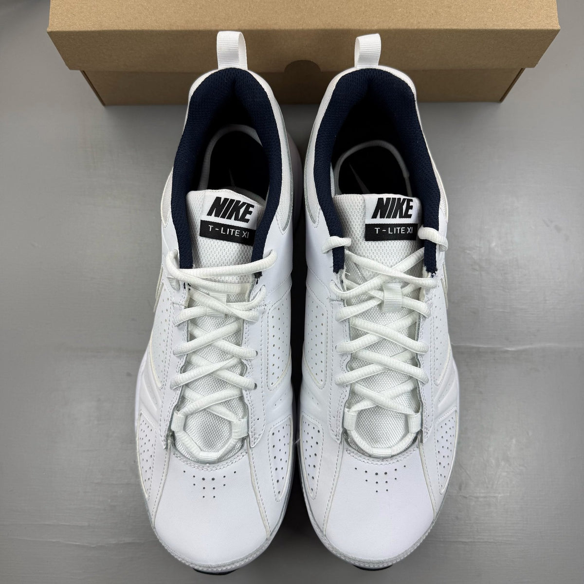 Nike white running trainers with black and navy accents, featuring logo details.