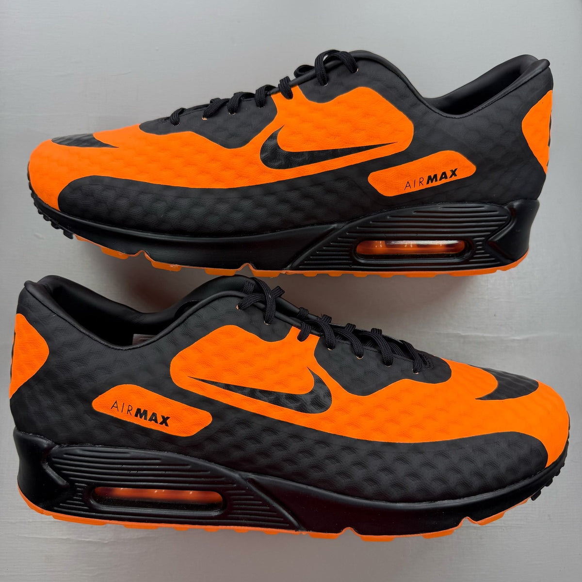 Nike black trainers with bright citrus accents and Hypervenom design details.