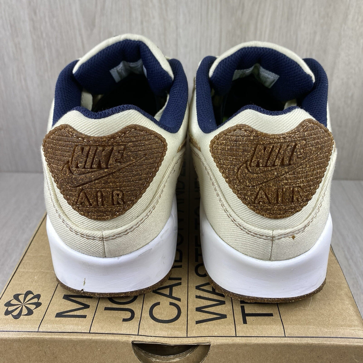 Nike Air Max 90 SE white trainers with cork accents and logo detail.