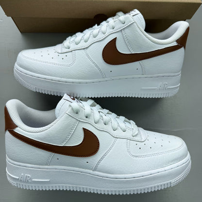Nike Air Force 1 trainers white with brown accents and signature logo detail.