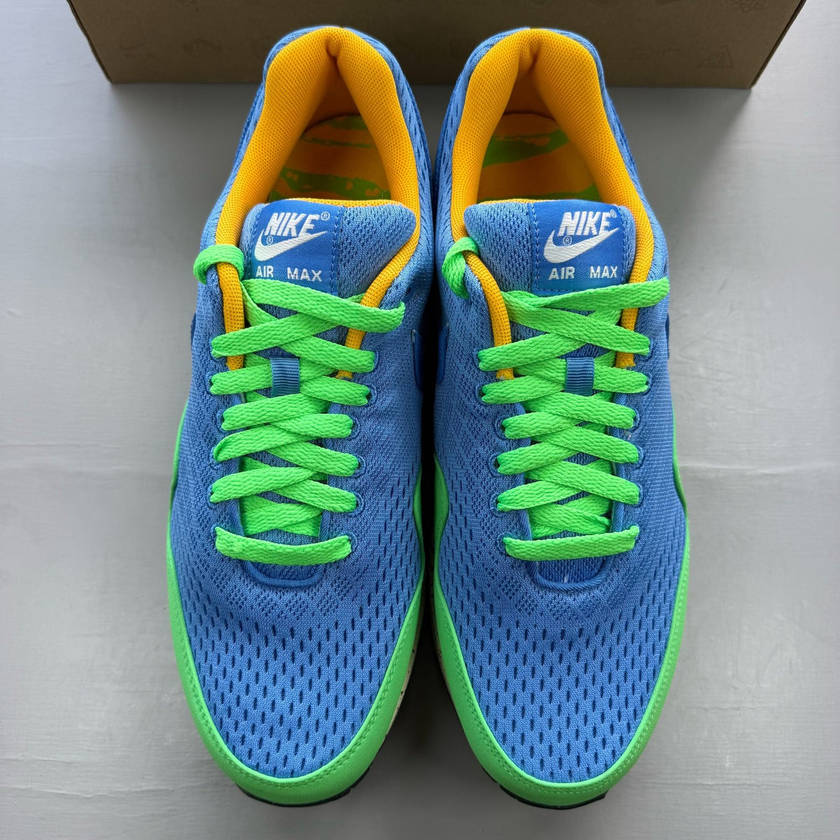 Nike Air Max 1 EM blue trainers with mesh upper and signature swoosh logo.
