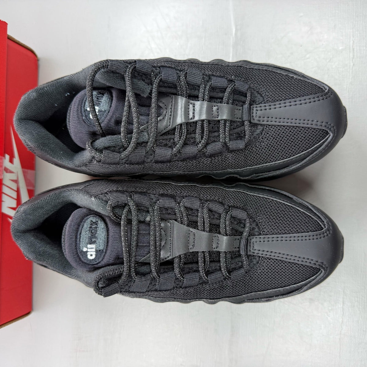 Nike Air Max 95 black trainers with big bubble sole and logo detail.