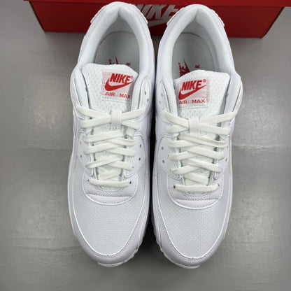 Nike Air Max 90 white trainers with light crimson accents and signature swoosh logo.