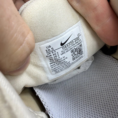 Nike beige trainers with black accents and Air cushioning design.