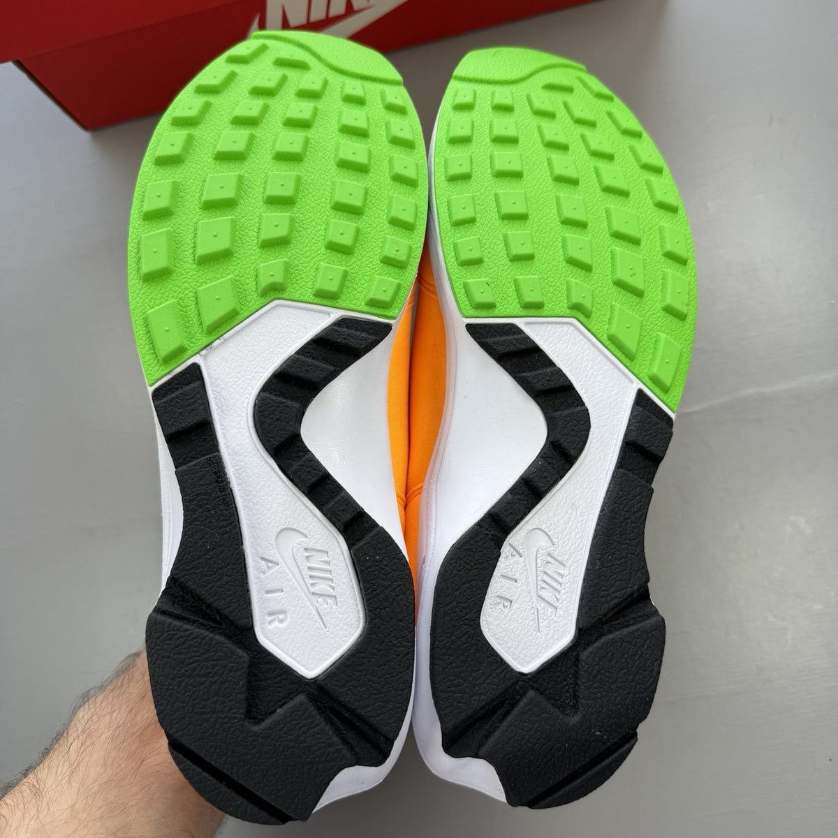 Nike Air Huarache Light white trainers with atomic mango accents and green details.