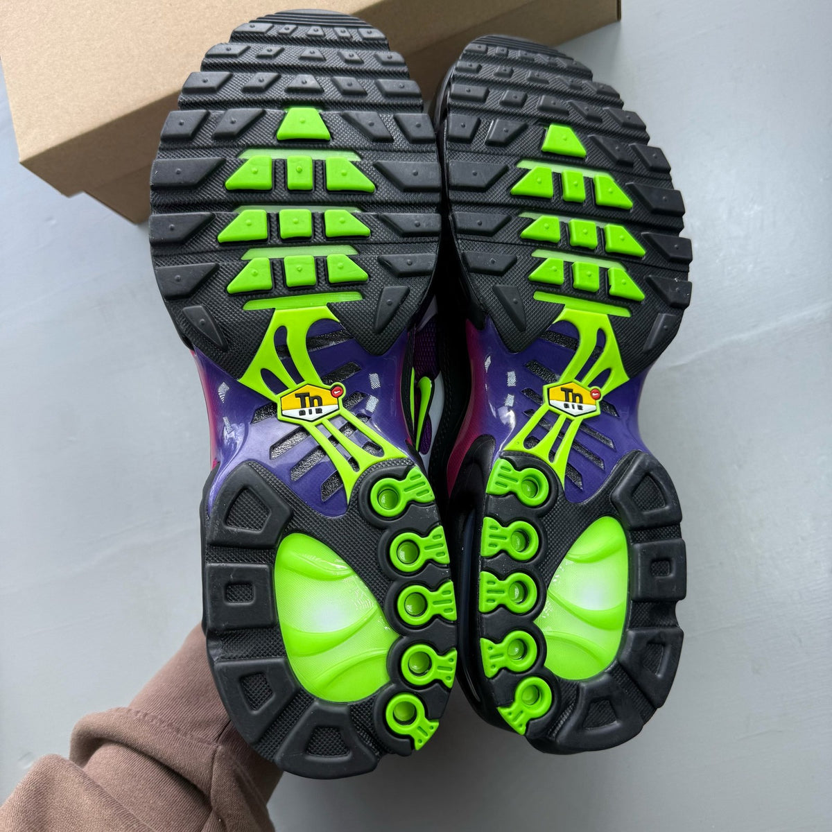 Nike Air Max Plus TN pink and purple trainers with distinctive wave pattern and logo.