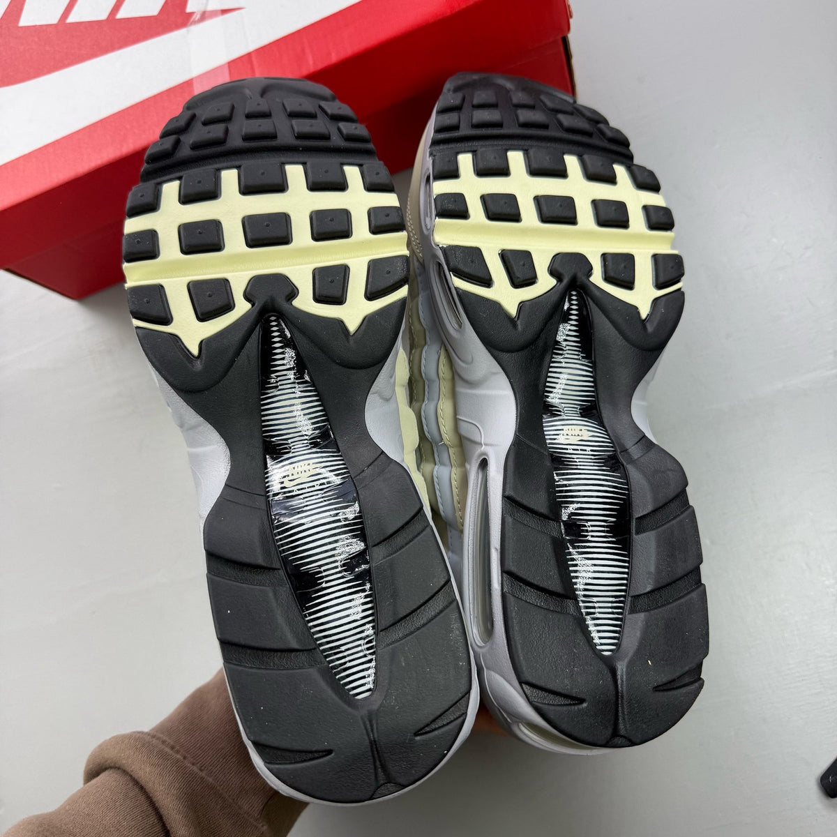 Nike Air Max 95 beige trainers with desert khaki accents and logo detailing.