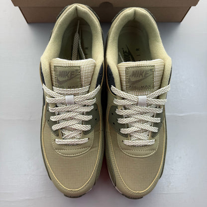 Nike Air Max 90 neutral olive green trainers with black accents and logo details.