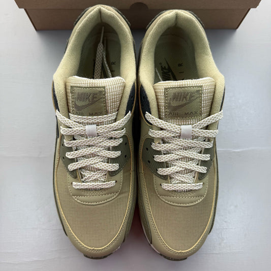 Nike Air Max 90 neutral olive green trainers with black accents and logo details.