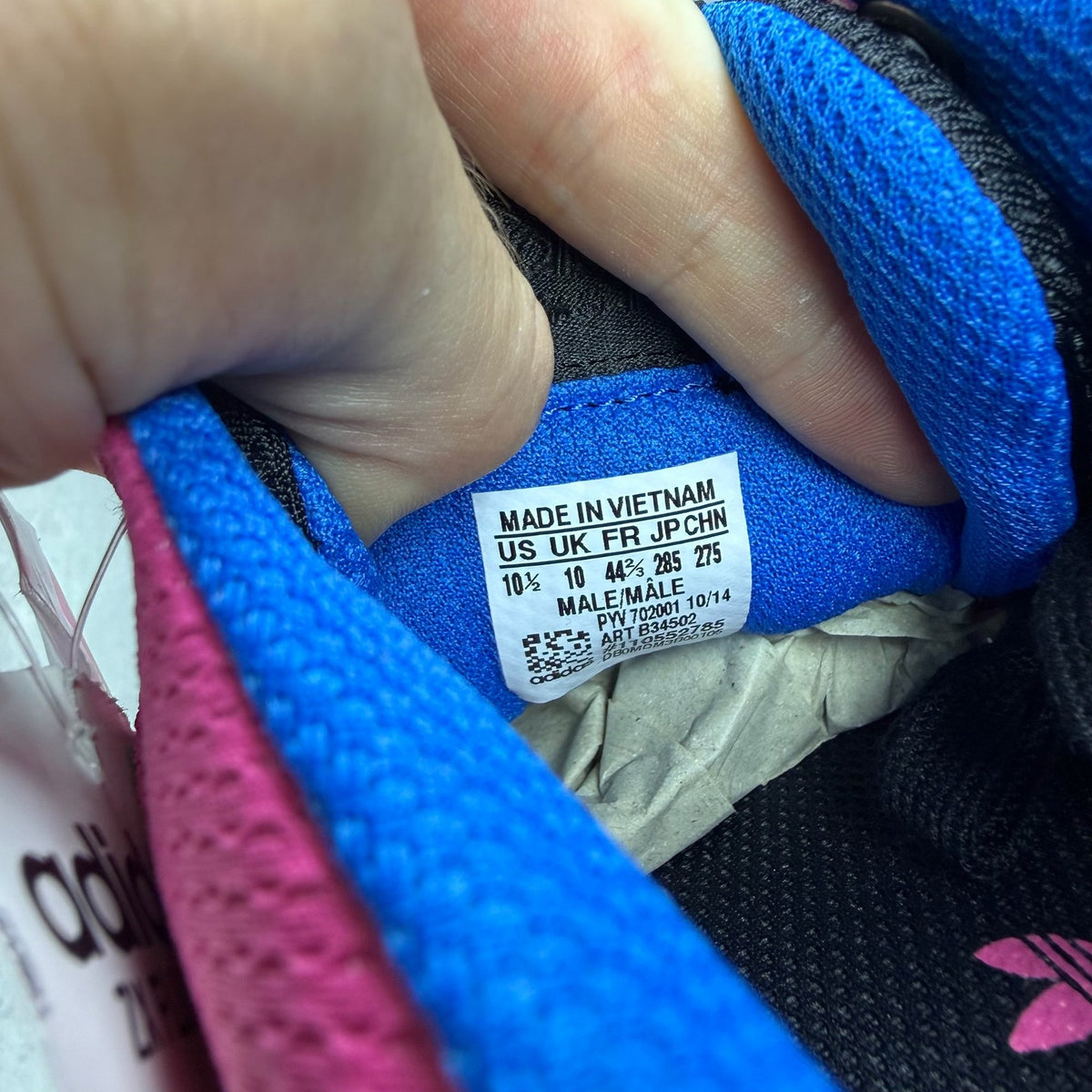 Adidas ZX Flux trainers in shock pink with black and blue accents, mesh upper.