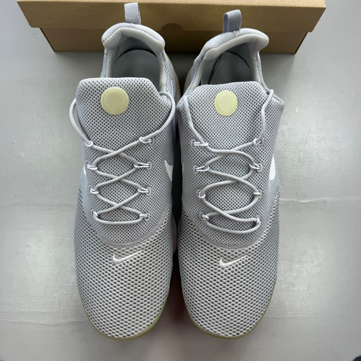Nike running shoes grey mesh upper with white sole and logo detail.