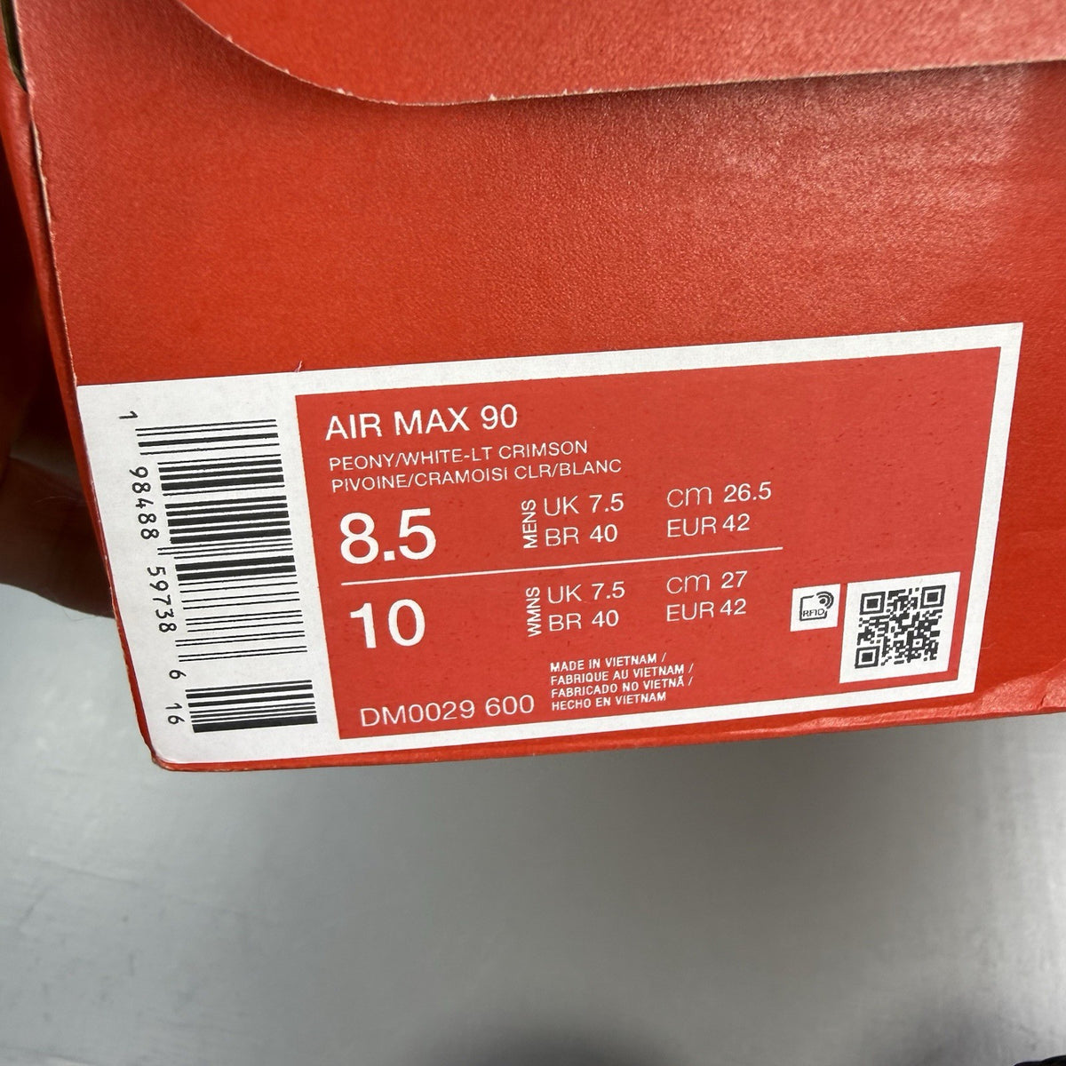 Nike Air Max 90 red trainers with white accents and signature swoosh logo.