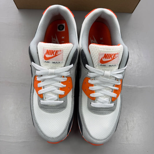Nike trainers white with safety orange accents and grey detailing, featuring iconic logo.