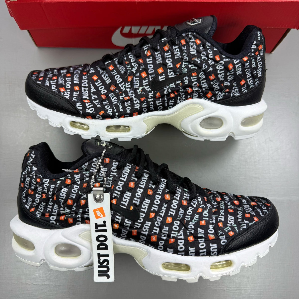 Nike black trainers featuring the Just Do It logo and sleek design.