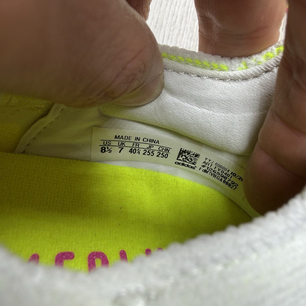 Adidas Ultra Boost 21 white trainers with solar yellow accents and signature three-stripe logo.