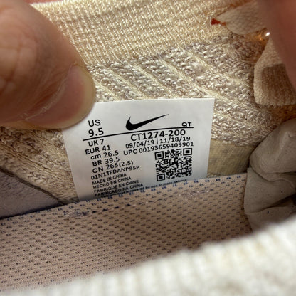 Nike trainers light cream pink Flyknit material with Air cushioning and logo details.