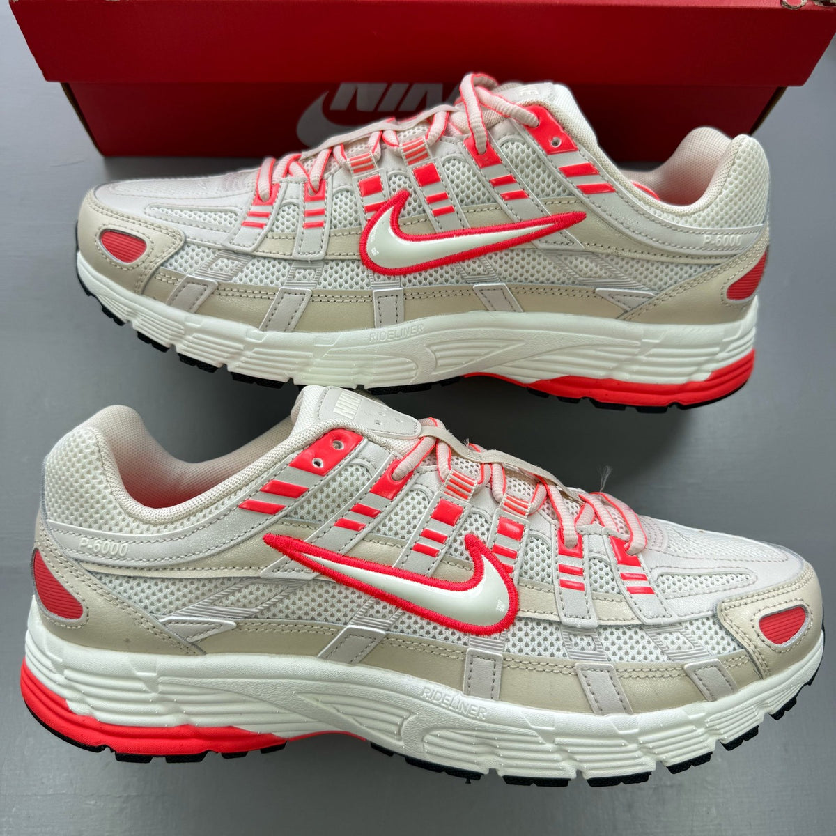 Nike P-6000 trainers white with red accents and mesh detailing, brand logo on tongue.