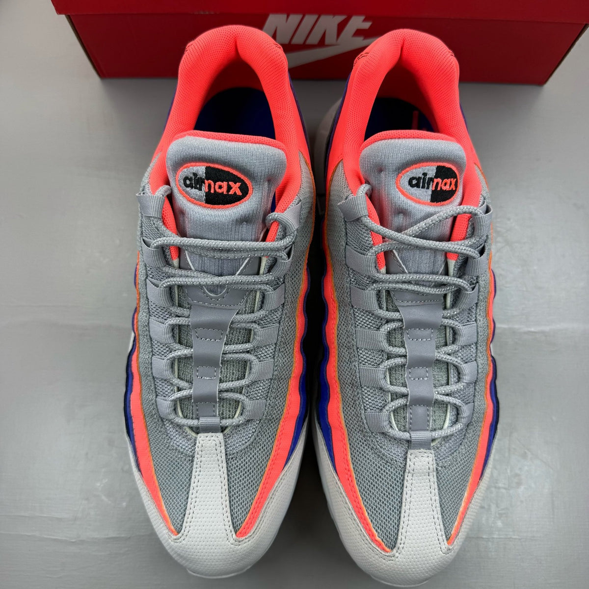 Nike Air Max 95 grey sneakers with Ultramarine and Platinum accents, featuring logo detail.