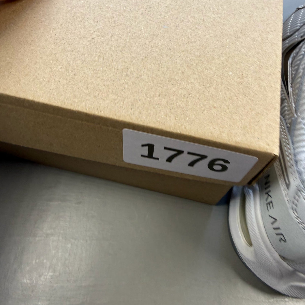 Nike Air Max Torch 4 grey and white trainers with mesh upper and signature swoosh logo.