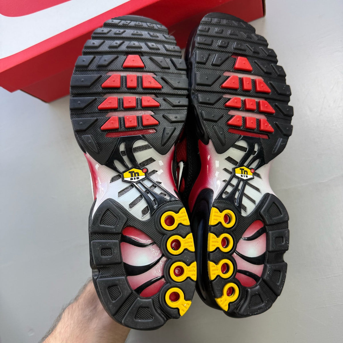 Nike Air Max Plus TN red with pure platinum accents and iconic logo detail.