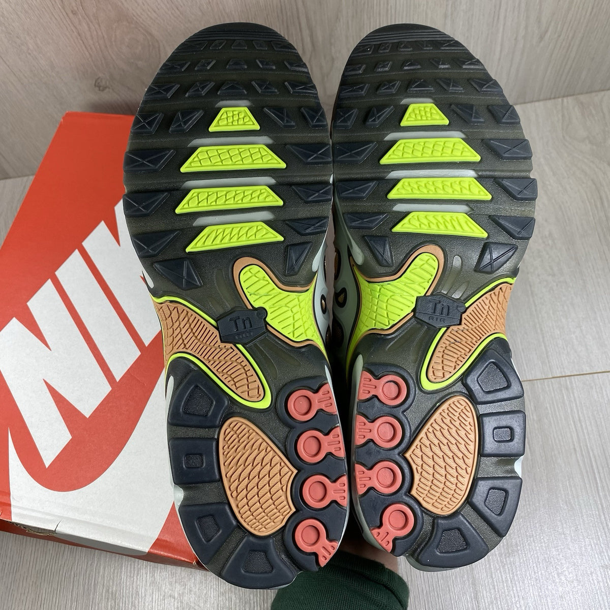 Nike Air Max Plus TN trainers silver with volt accents and signature logo details.