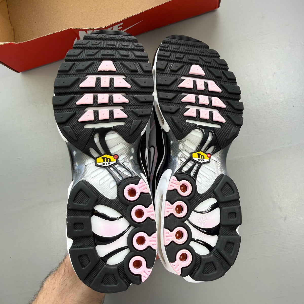Nike trainers white with pink accents and black detailing, featuring Air Max cushioning.