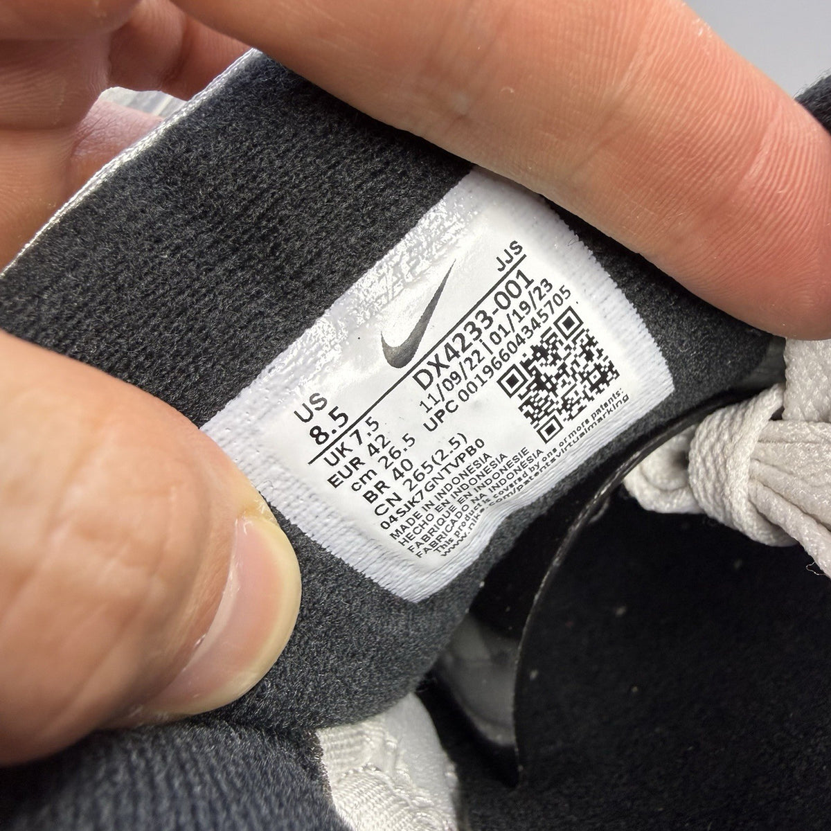 Nike Air Max 90 Icons grey trainers with red accents and white sole, featuring logo details.
